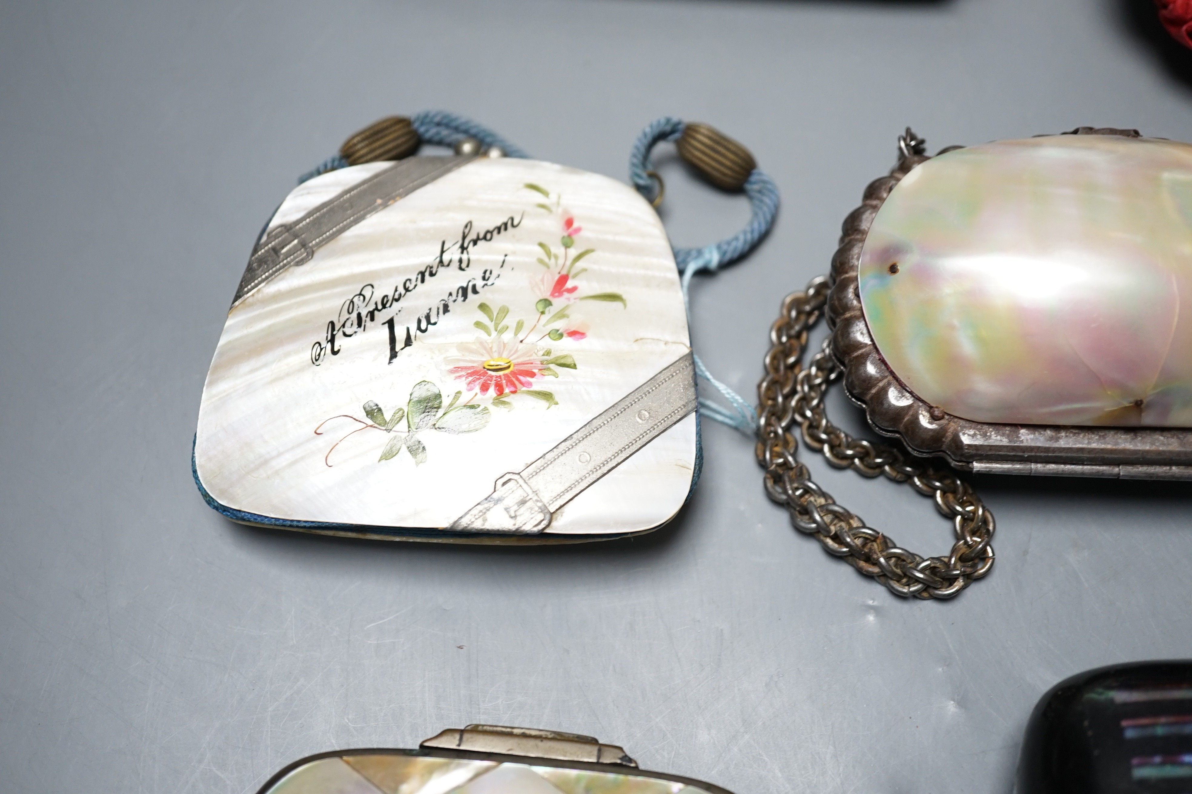 A collection of six mother of pearl souvenir purses, possibly from a grand tour and a papier-mâché mache card case and glasses case, card case 14 cms wide